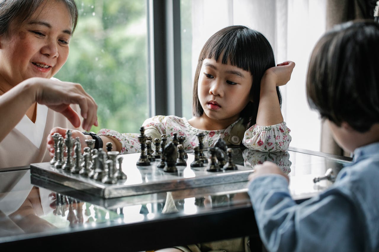 A family enjoys a thoughtful and educational game of chess, spending quality time together indoors.